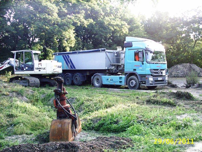 Sattelkipper beim Kippen von Sand auf einer Baustelle
