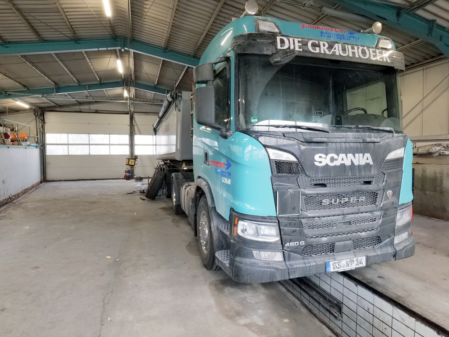 Mitarbeiter in der Werkstatt bei der Wartung eines LKW mit C/CE Führerschein