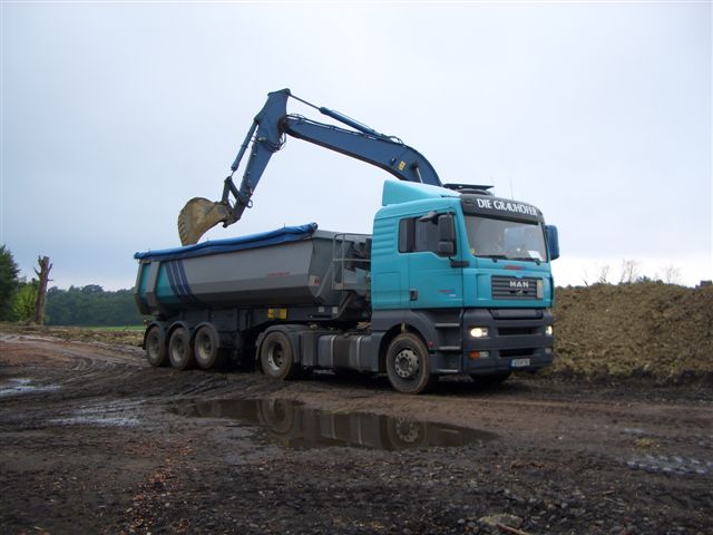Sattelzug wird auf einer Baustelle mit Sand und Kies beladen